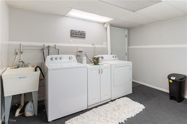 clothes washing area with separate washer and dryer and sink