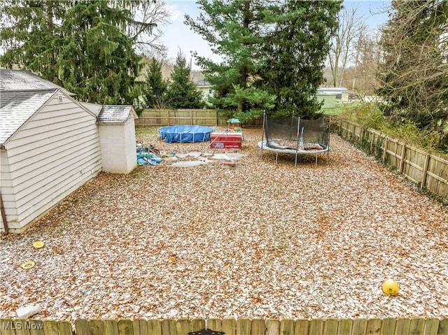 view of yard featuring a covered pool and a trampoline