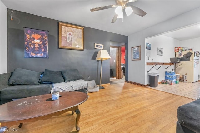 living room with ceiling fan and light wood-type flooring