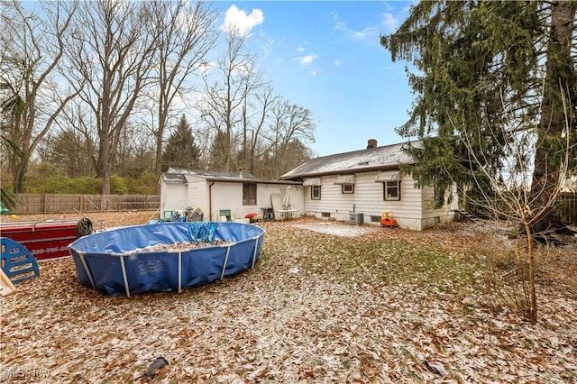 rear view of property with a covered pool and cooling unit