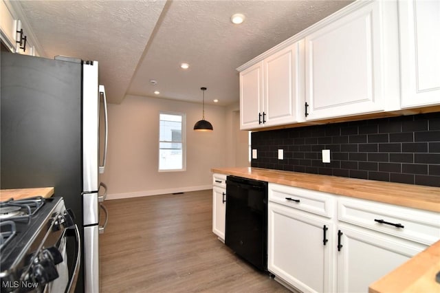 kitchen featuring butcher block counters, dishwasher, light hardwood / wood-style floors, decorative light fixtures, and white cabinets