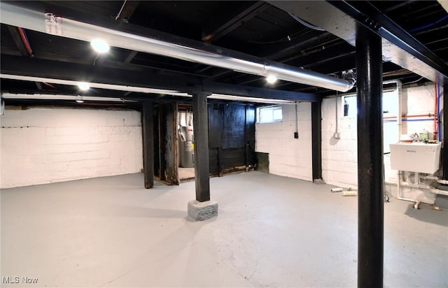 basement featuring electric water heater and sink