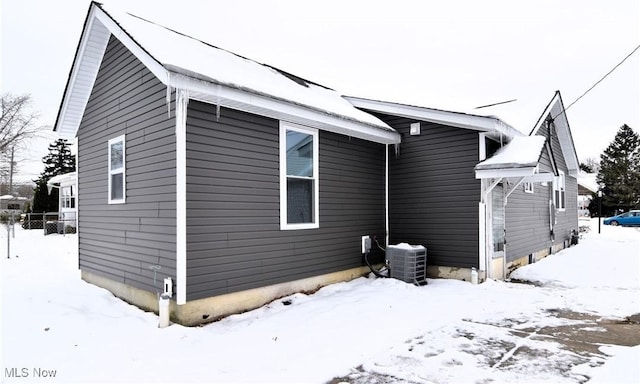 snow covered property with central air condition unit