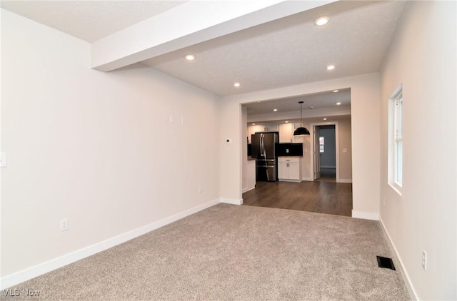 unfurnished living room featuring dark carpet