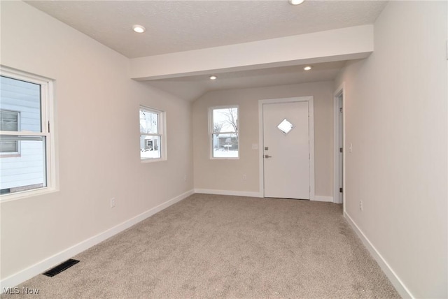 foyer featuring a textured ceiling and light colored carpet