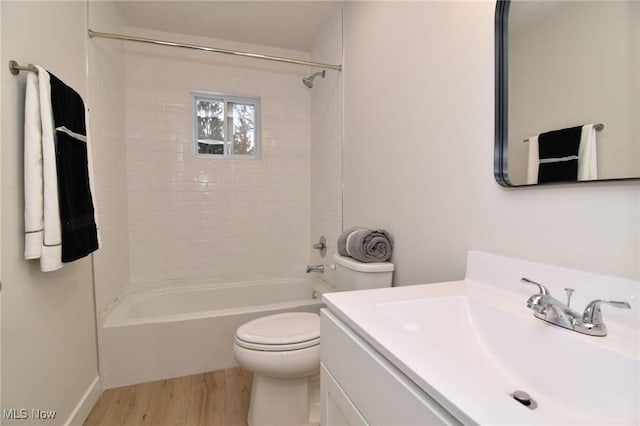 full bathroom featuring vanity, hardwood / wood-style flooring, toilet, and tiled shower / bath combo