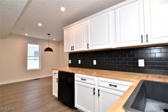 kitchen with white cabinets, black dishwasher, hanging light fixtures, and wooden counters