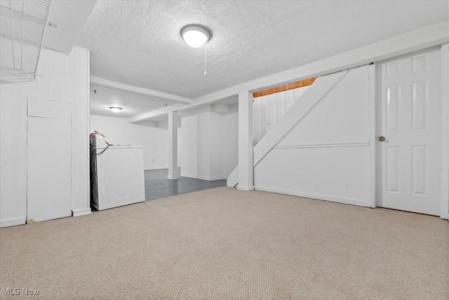 basement featuring washer / dryer, a textured ceiling, and carpet floors