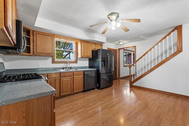 kitchen featuring sink, ceiling fan, light wood-type flooring, a textured ceiling, and appliances with stainless steel finishes