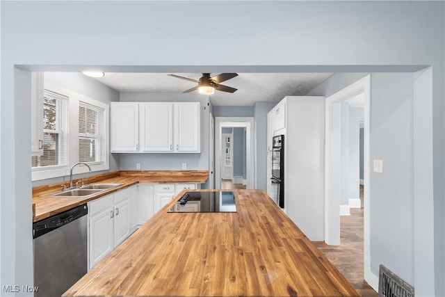 kitchen featuring wood counters, black appliances, white cabinets, sink, and light hardwood / wood-style flooring