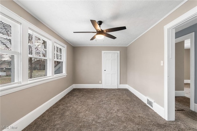 carpeted spare room with a textured ceiling, plenty of natural light, ceiling fan, and crown molding