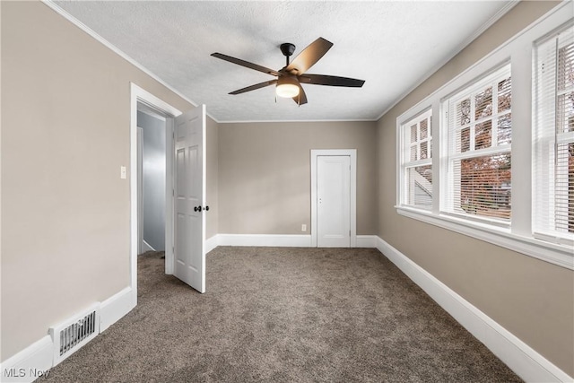 unfurnished bedroom with ceiling fan, carpet floors, a textured ceiling, and ornamental molding