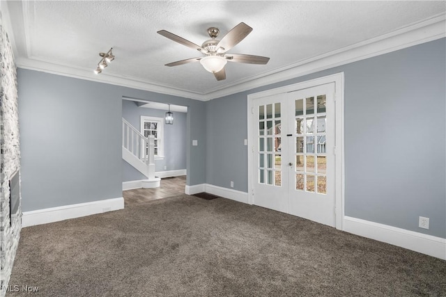 empty room featuring french doors, ornamental molding, a textured ceiling, ceiling fan, and dark colored carpet