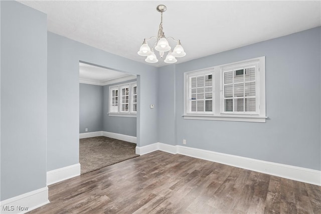 unfurnished room with hardwood / wood-style floors and a notable chandelier