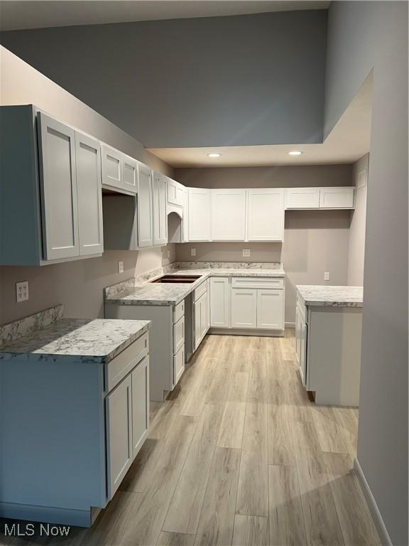 kitchen featuring light hardwood / wood-style floors, white cabinetry, and black electric cooktop