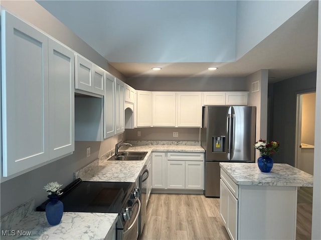 kitchen featuring sink, white cabinetry, stainless steel appliances, and light wood-type flooring