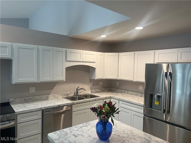 kitchen featuring sink, white cabinetry, light stone countertops, lofted ceiling, and stainless steel appliances