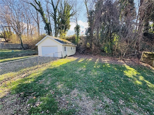 view of yard with a garage and an outbuilding