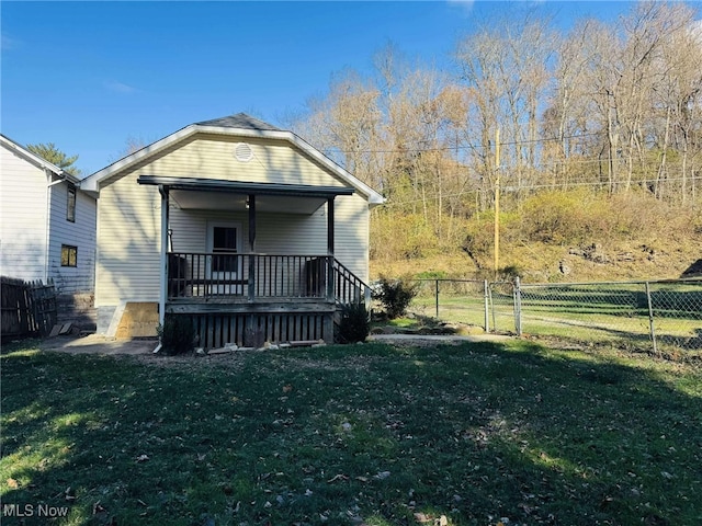 rear view of house featuring a porch and a lawn