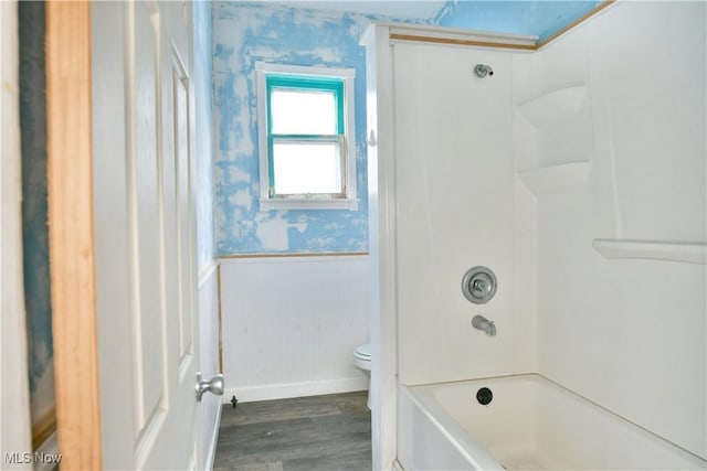 full bathroom with wallpapered walls, wood finished floors, toilet, wainscoting, and baseboards