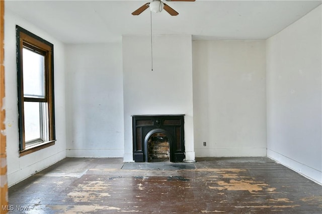 unfurnished living room featuring plenty of natural light, ceiling fan, and baseboards