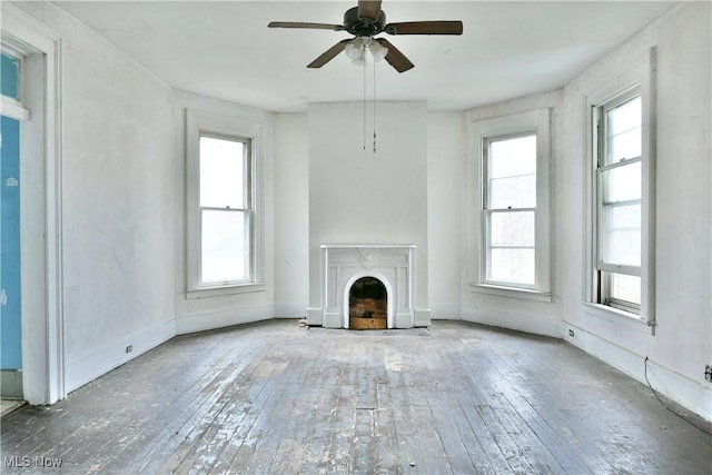 unfurnished living room with hardwood / wood-style flooring, plenty of natural light, and a ceiling fan