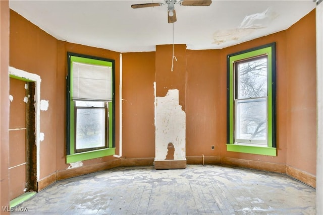 empty room featuring a ceiling fan and baseboards