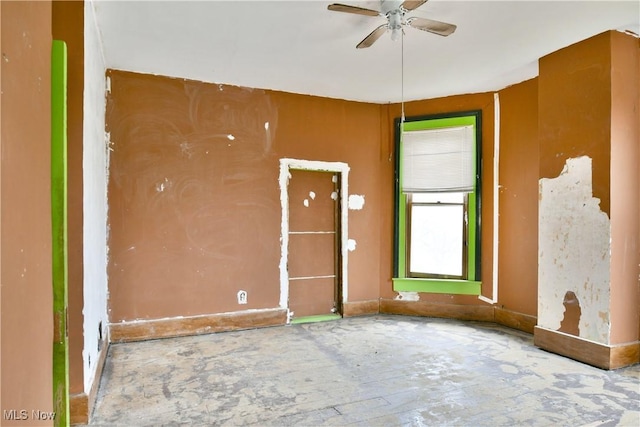 unfurnished room with ceiling fan and baseboards