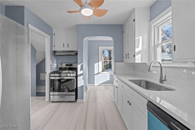 kitchen featuring stainless steel appliances, white cabinetry, a healthy amount of sunlight, and sink