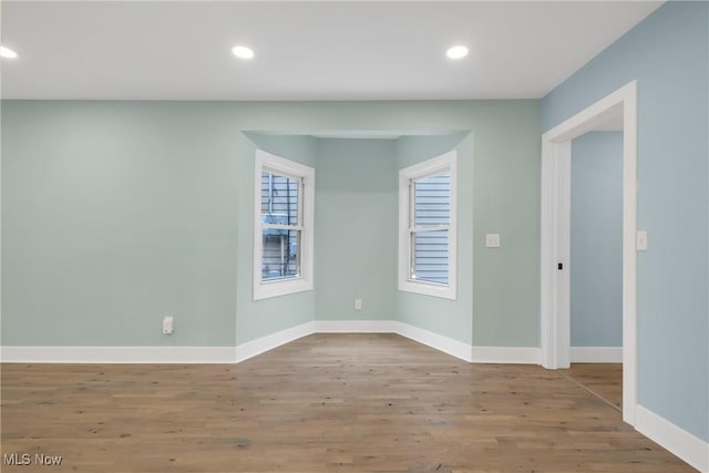 unfurnished room with recessed lighting, baseboards, and wood finished floors