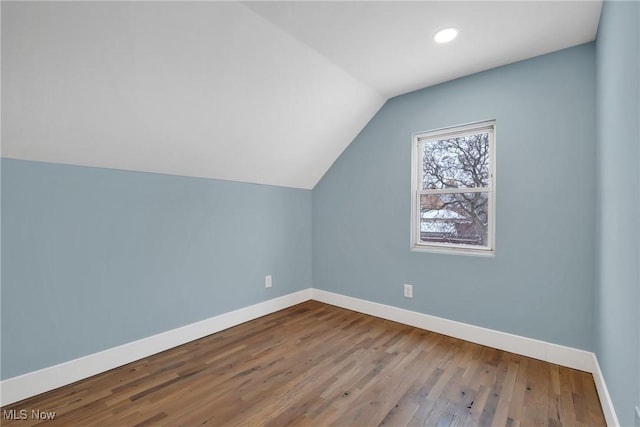 bonus room featuring baseboards, vaulted ceiling, and wood finished floors