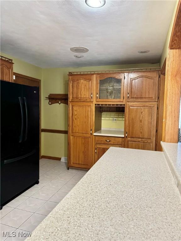 kitchen featuring black fridge and light tile patterned flooring