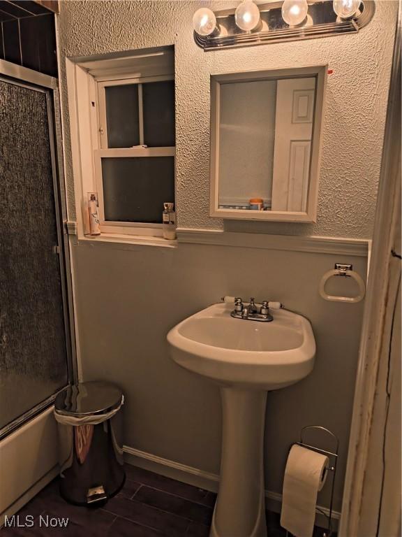 bathroom with combined bath / shower with glass door