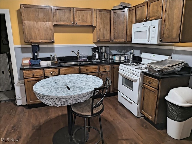 kitchen featuring sink, dark wood-type flooring, and white appliances