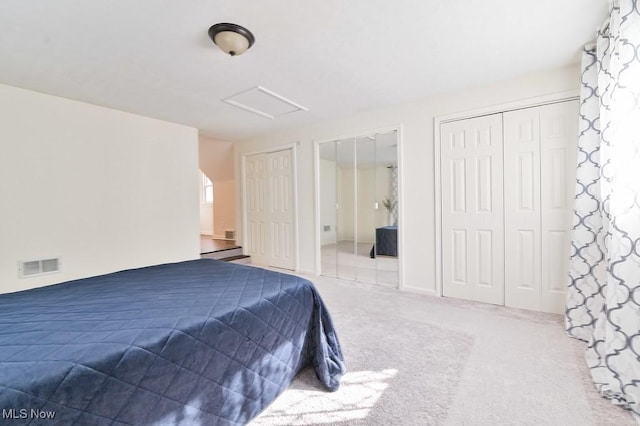 bedroom featuring multiple closets and carpet floors