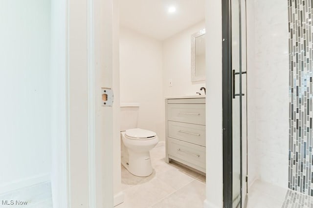 bathroom with tile patterned flooring, vanity, a shower with shower door, and toilet