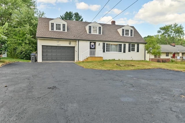 cape cod house featuring a garage and a front lawn