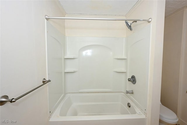 bathroom featuring a textured ceiling, toilet, and shower / washtub combination