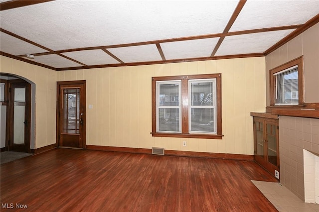 unfurnished living room with a textured ceiling, dark hardwood / wood-style flooring, and a brick fireplace