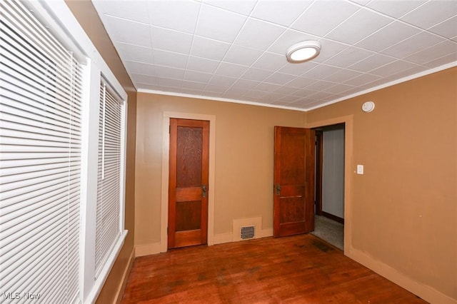 unfurnished bedroom featuring dark hardwood / wood-style flooring and crown molding