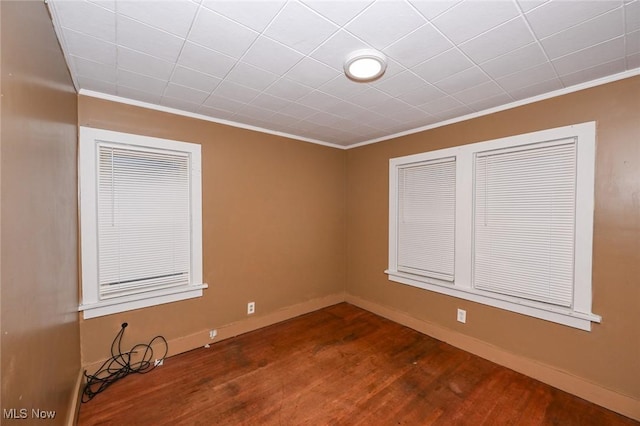 spare room featuring dark hardwood / wood-style flooring and ornamental molding