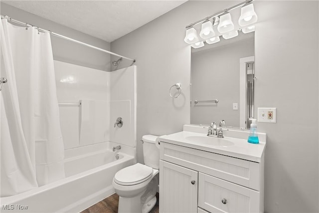 full bathroom with hardwood / wood-style floors, vanity, toilet, shower / bath combo with shower curtain, and a textured ceiling