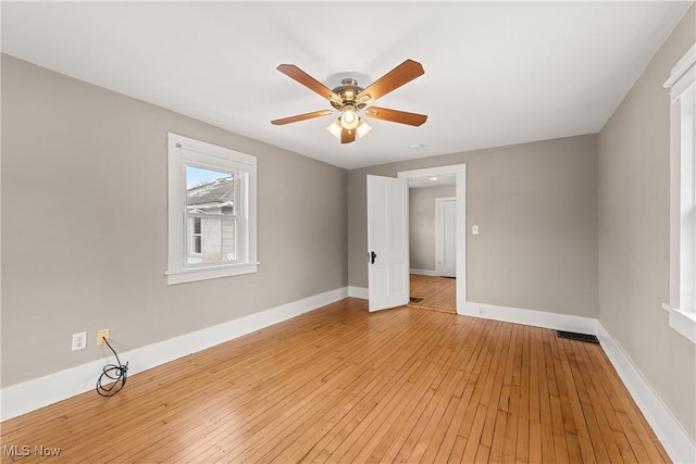 empty room with ceiling fan and light hardwood / wood-style flooring