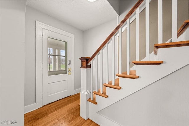 entryway with light hardwood / wood-style flooring and a textured ceiling