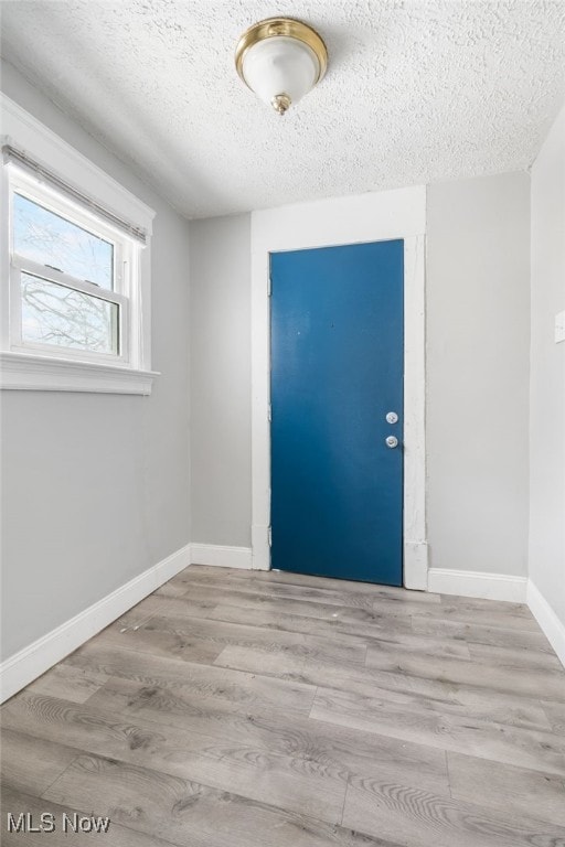 spare room featuring a textured ceiling and light wood-type flooring