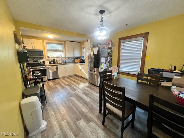 dining space featuring a textured ceiling and light hardwood / wood-style flooring