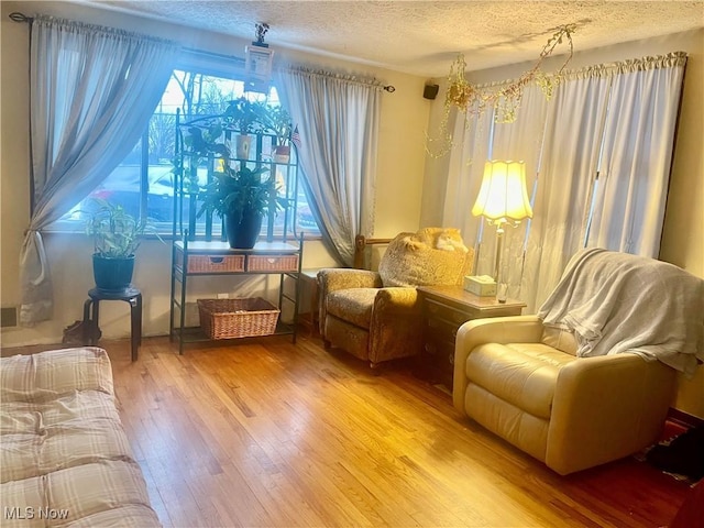 living area with hardwood / wood-style flooring and a textured ceiling