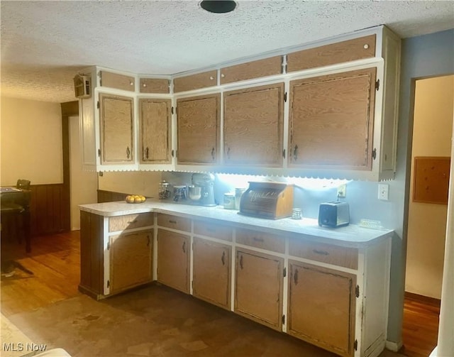 kitchen with wood-type flooring and a textured ceiling