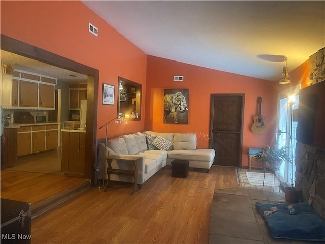 living room with vaulted ceiling and light wood-type flooring