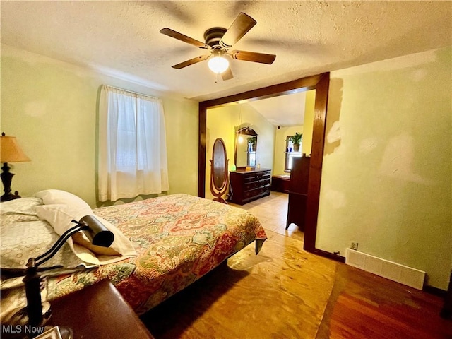 bedroom featuring a textured ceiling, light hardwood / wood-style flooring, and ceiling fan